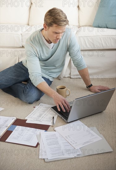 Man working on laptop in livingroom.