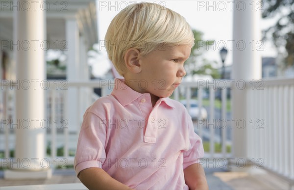 Boy sitting on porch. Photographe : mark edward atkinson