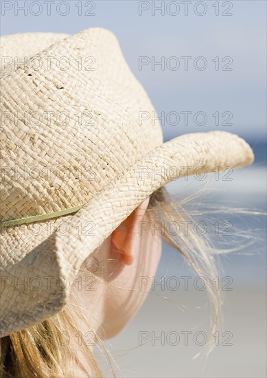 Woman in cowboy hat on beach. Photographe : Jamie Grill