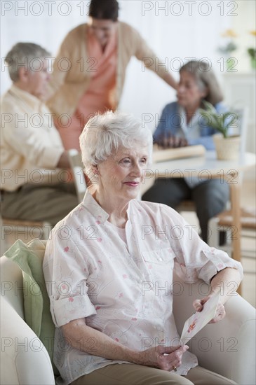 Senior woman reading greeting card.