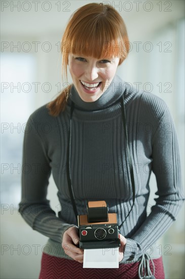 Woman holding vintage camera.