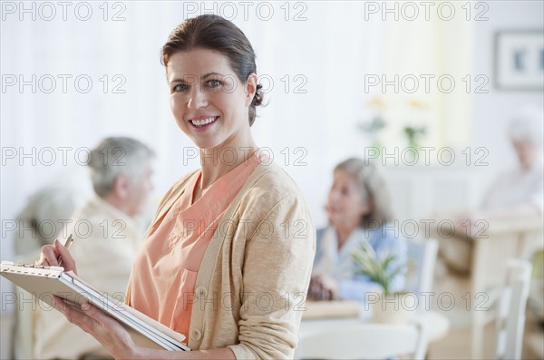 Nurse writing on patient’s medical chart.