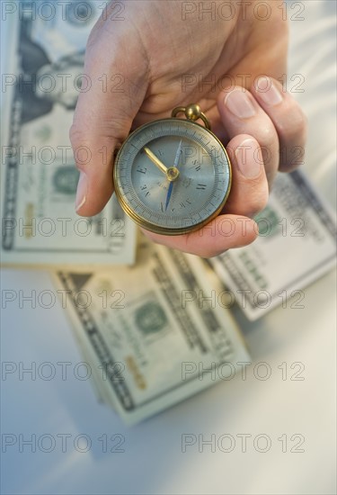 Man holding compass over money.