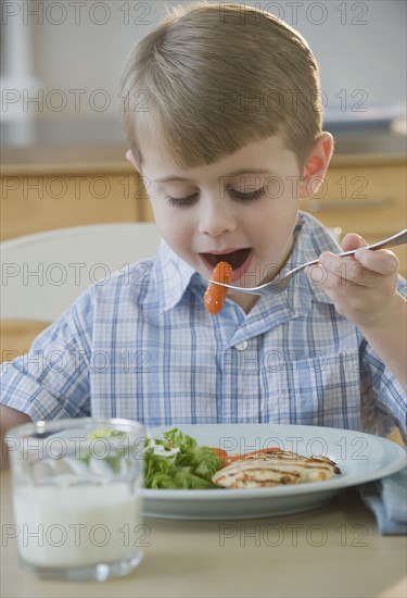 Boy eating dinner.