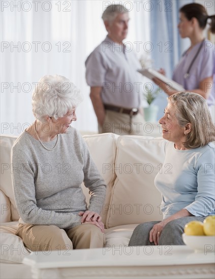 Senior woman talking on sofa.