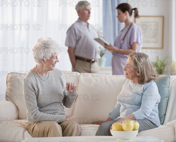 Senior woman talking on sofa.