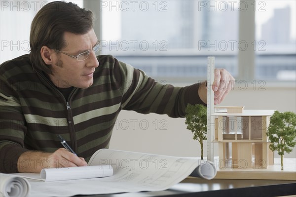 Architect measuring model home.