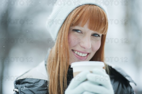 Woman drinking coffee in snow.