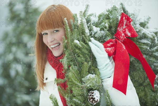 Woman carrying Christmas wreath.