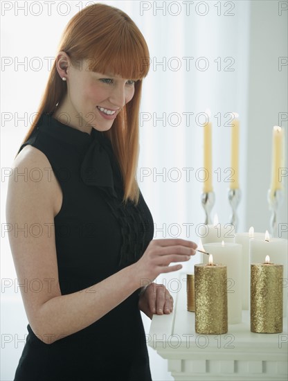 Woman lighting holiday candles.