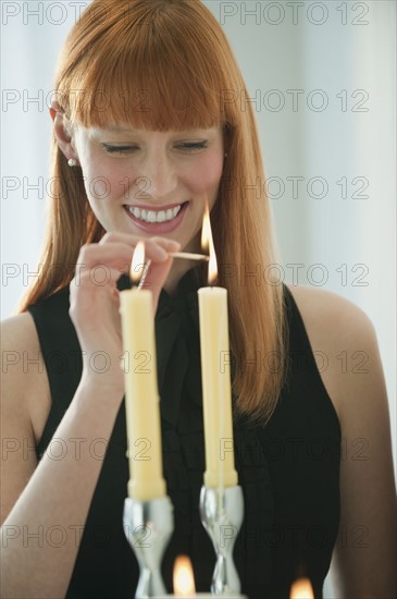 Woman lighting holiday candles.