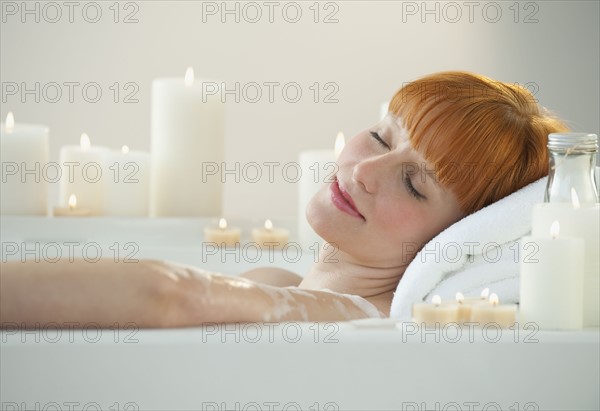 Woman relaxing in bathtub.