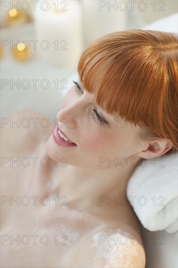 Woman relaxing in bathtub.