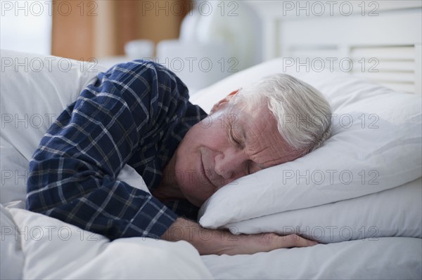 Senior man sleeping in bed.