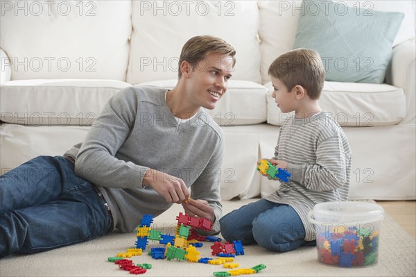 Father playing with son in livingroom.