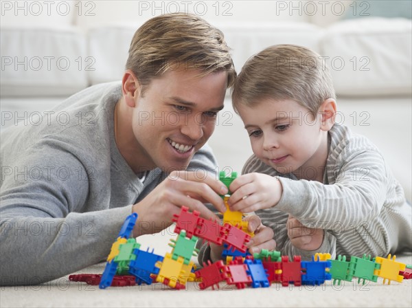 Father playing with son in livingroom.