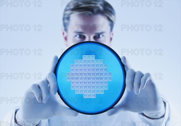 Man holding computer chip.