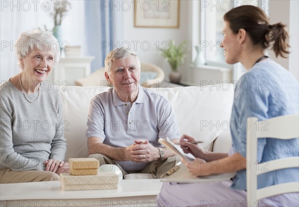 Nurse talking to senior adults.