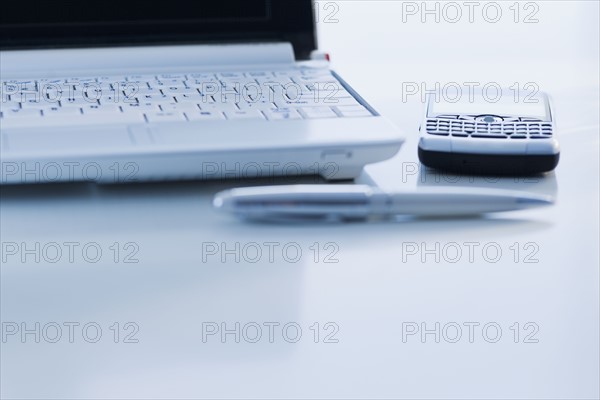 Cell phone and laptop on desk.