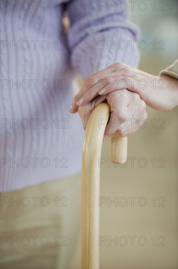 Close up of senior woman holding cane.