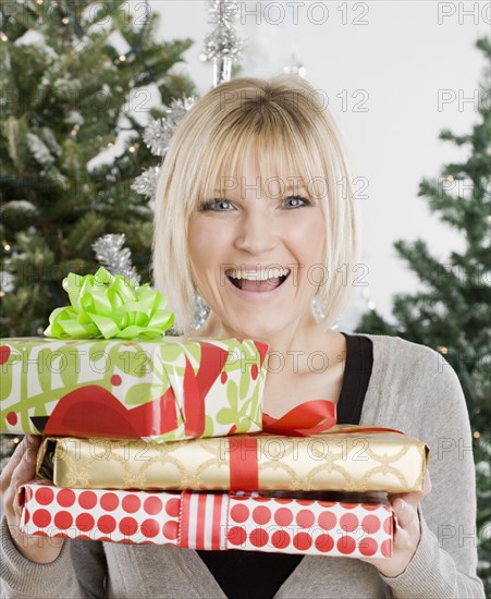 Woman holding Christmas gifts. Photographe : Jamie Grill