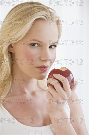 Woman eating apple. Photographe : Daniel Grill