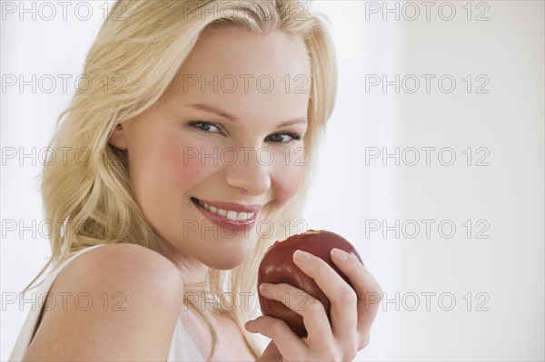 Woman eating apple. Photographe : Daniel Grill