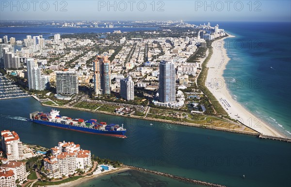 Aerial view of waterfront city and cargo ship. Photographe : fotog