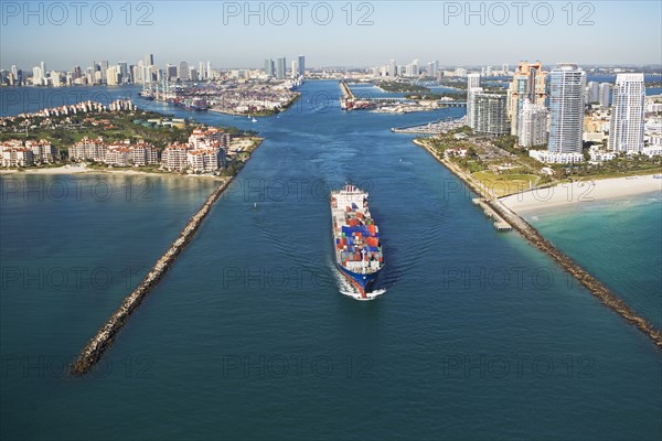 Aerial view of waterfront city and cargo ship. Photographe : fotog