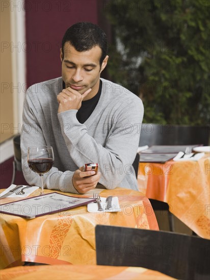 Man text messaging in restaurant.