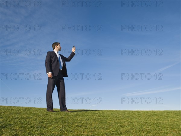 Businessman using cell phone outdoors.