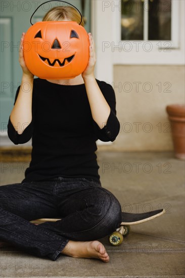 Girl holding plastic jack-o-lantern bucket. Photographe : Sarah M. Golonka