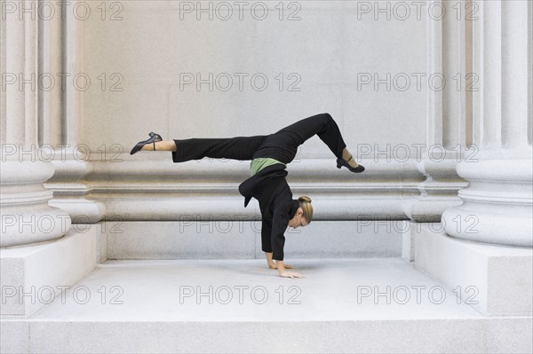 Businesswoman dancing in urban setting. Photographe : PT Images