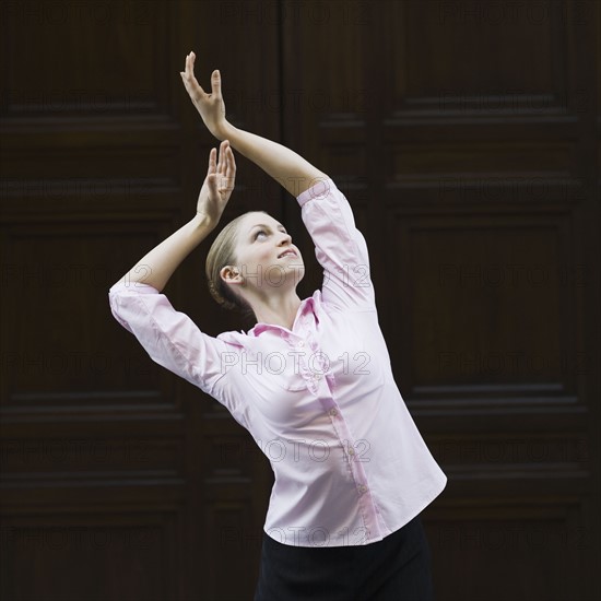 Businesswoman dancing in urban setting. Photographe : PT Images