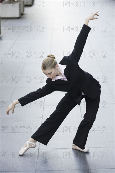 Businesswoman dancing in urban setting. Photographe : PT Images