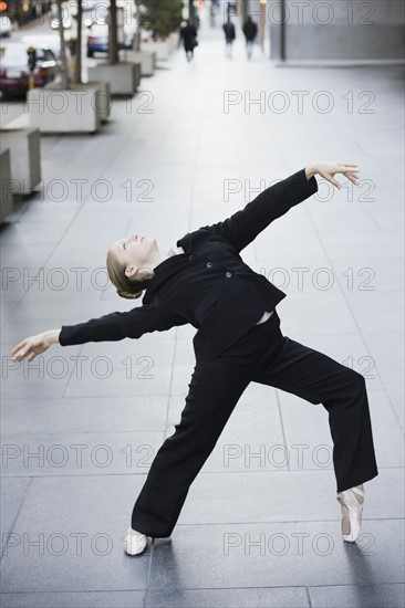 Businesswoman dancing in urban setting. Photographe : PT Images