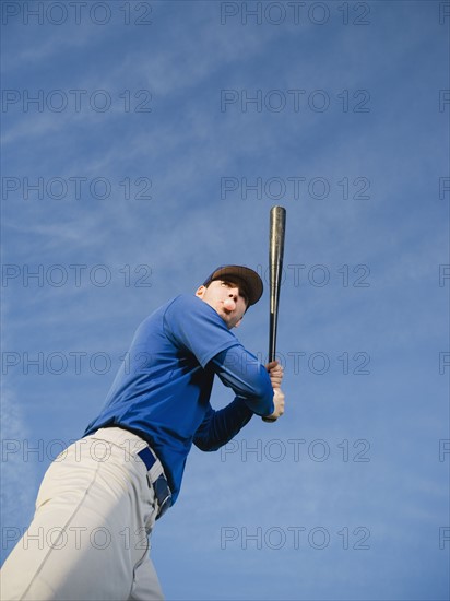 Baseball player swinging bat.