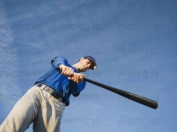 Baseball player swinging bat.