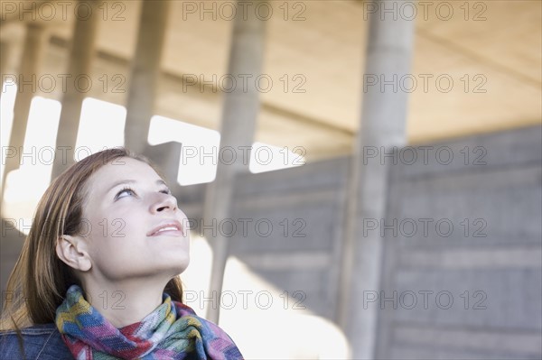 Young woman looking up. Photographe : PT Images