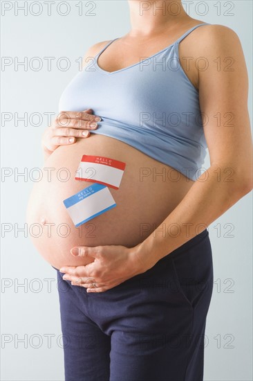 Pregnant woman with name tags on belly. Photographe : Jennifer L. Boggs