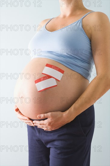 Pregnant woman with name tags on belly. Photographe : Jennifer L. Boggs