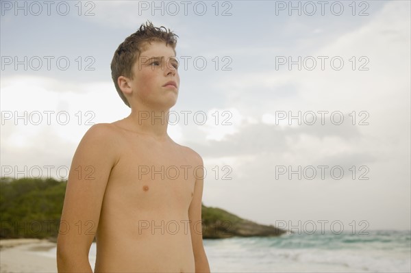 Boy standing on beach. Photographe : mark edward atkinson