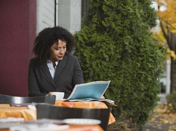 Businesswoman sitting at outdoor cafe.