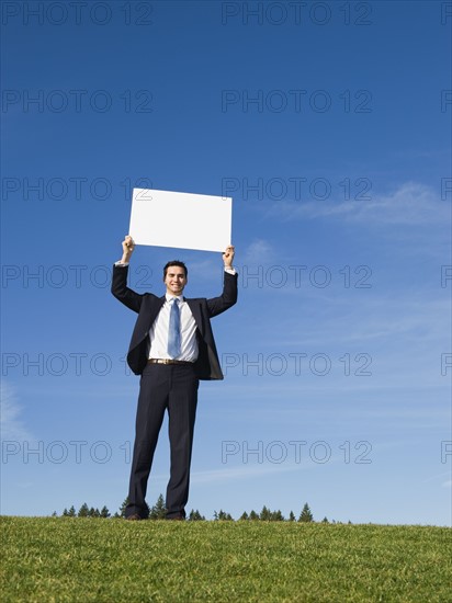 Businessman holding blank sign.