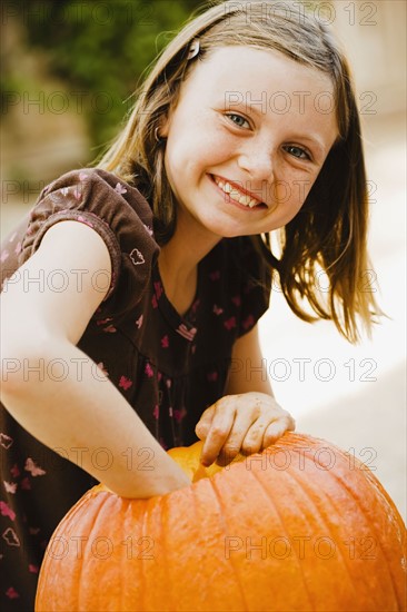 Girl scooping out pumpkin. Photographe : Sarah M. Golonka