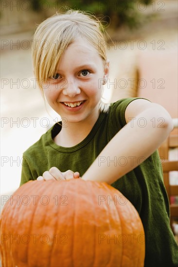 Girl scooping out pumpkin. Photographe : Sarah M. Golonka