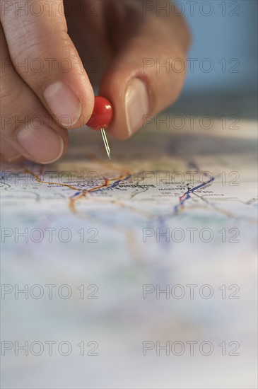 Man marking location on map. Photographe : Daniel Grill