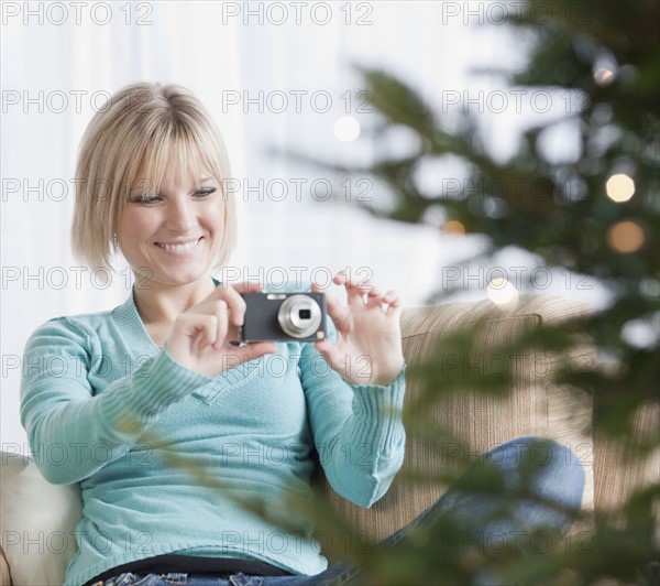 Woman photographing Christmas tree. Photographe : Jamie Grill