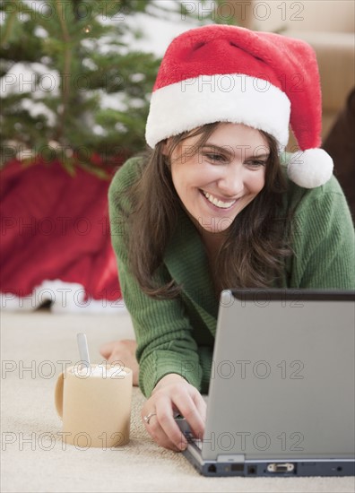 Woman using laptop at Christmas. Photographe : Jamie Grill