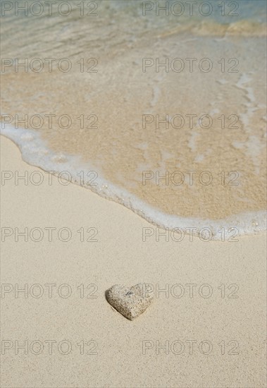 Heart shaped sand on beach.